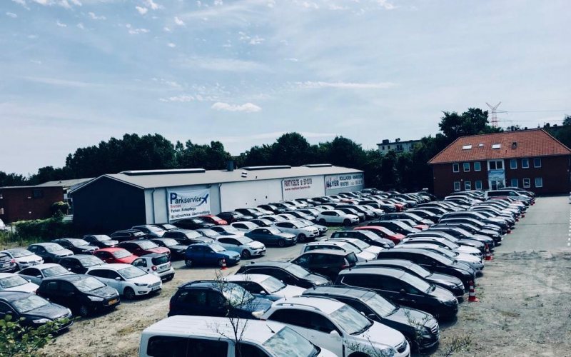 Der Parkplatz aus seitlicher Sicht mit der beschrifteten Halle von Parkservice Bremen