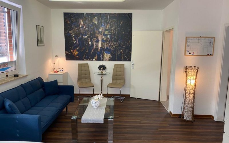 Aufenthaltsbereich mit Sofa, Stühlen und Stehlampe