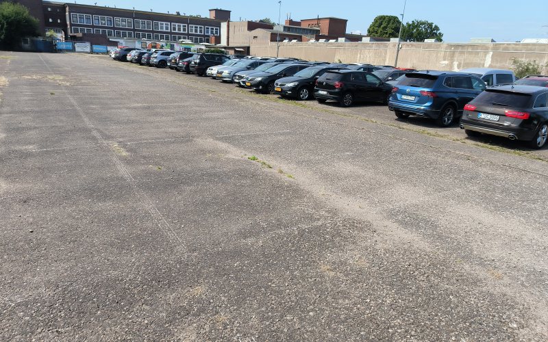 Fahrgasse zwischen den Stellplatzreihen von Holiday-Parking, dahinter Gewerbegebäude